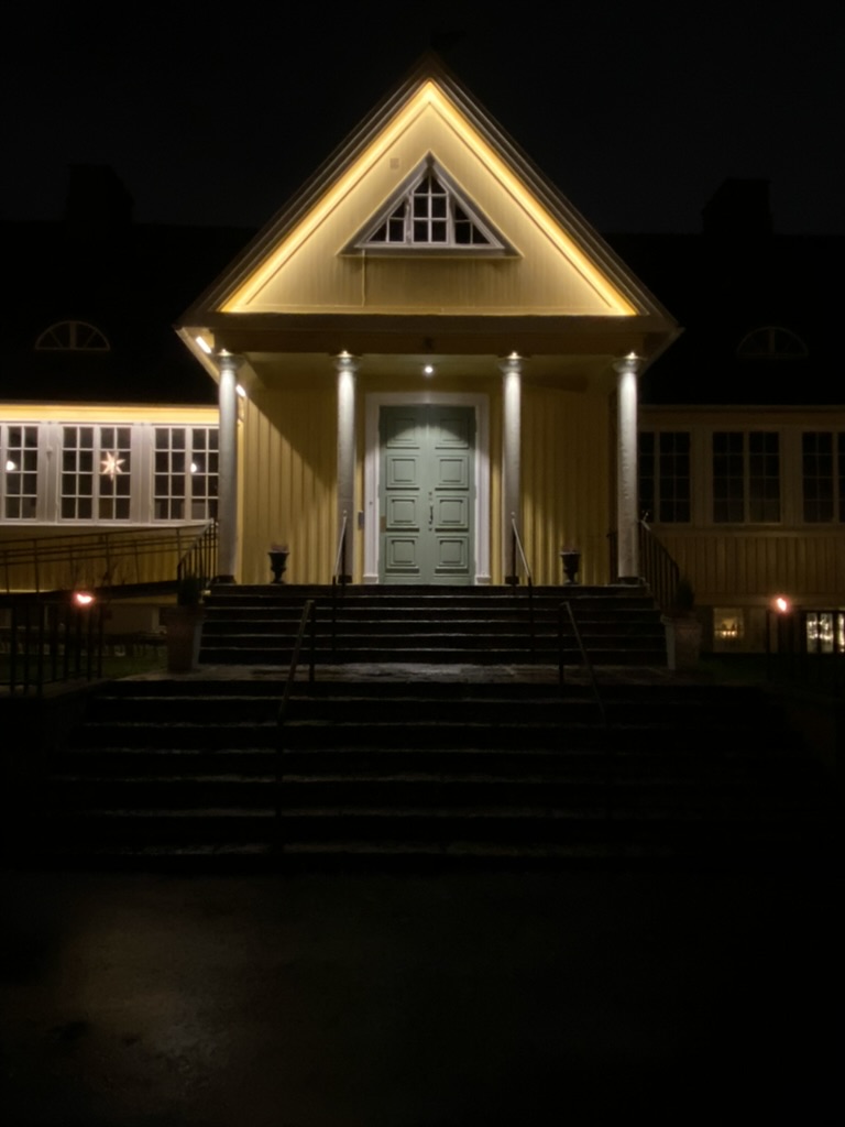 Nattbild med dramatisk belysning på pelare och gavel