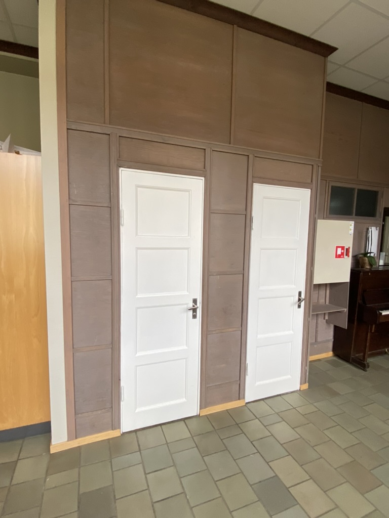 Hall med bruna panelväggar och kaklade golv