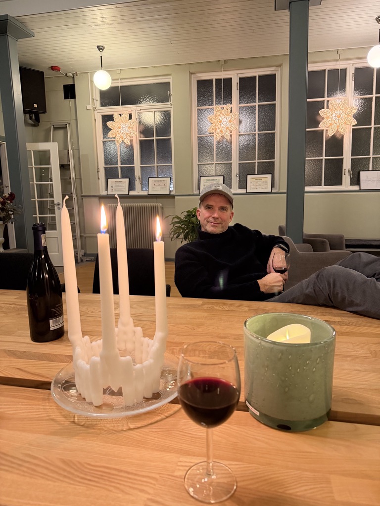 Mysig kväll vid bord med ljus och julstjärnor i fönstren