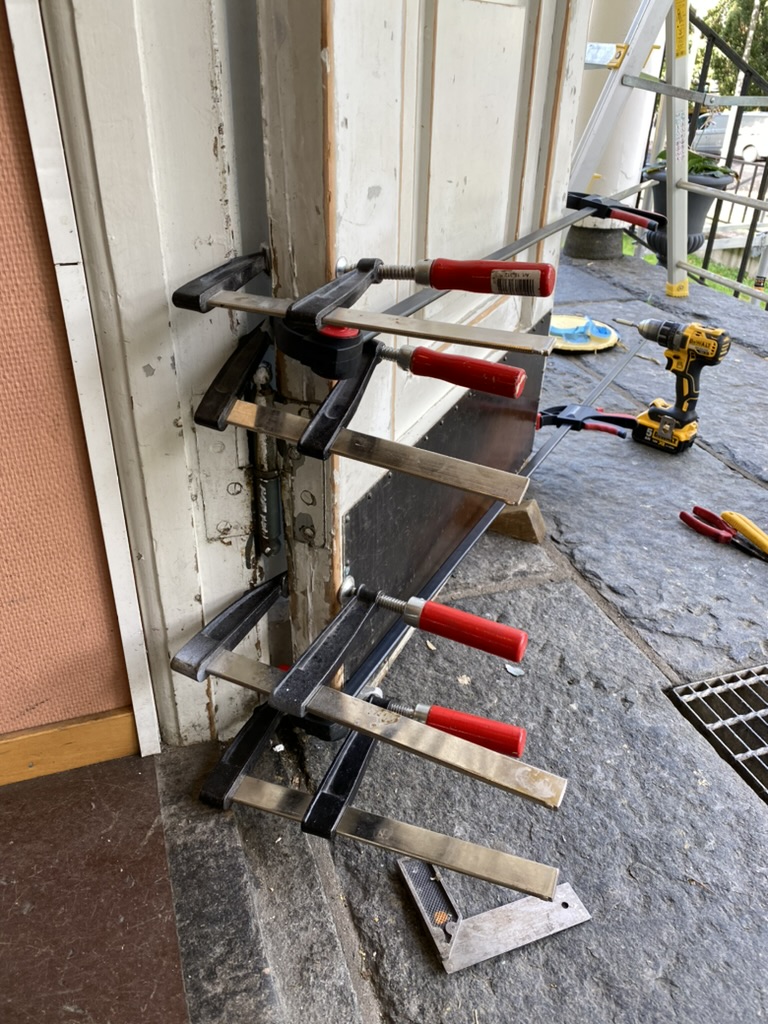 Trästycken limmas ihop med tvingar utomhus