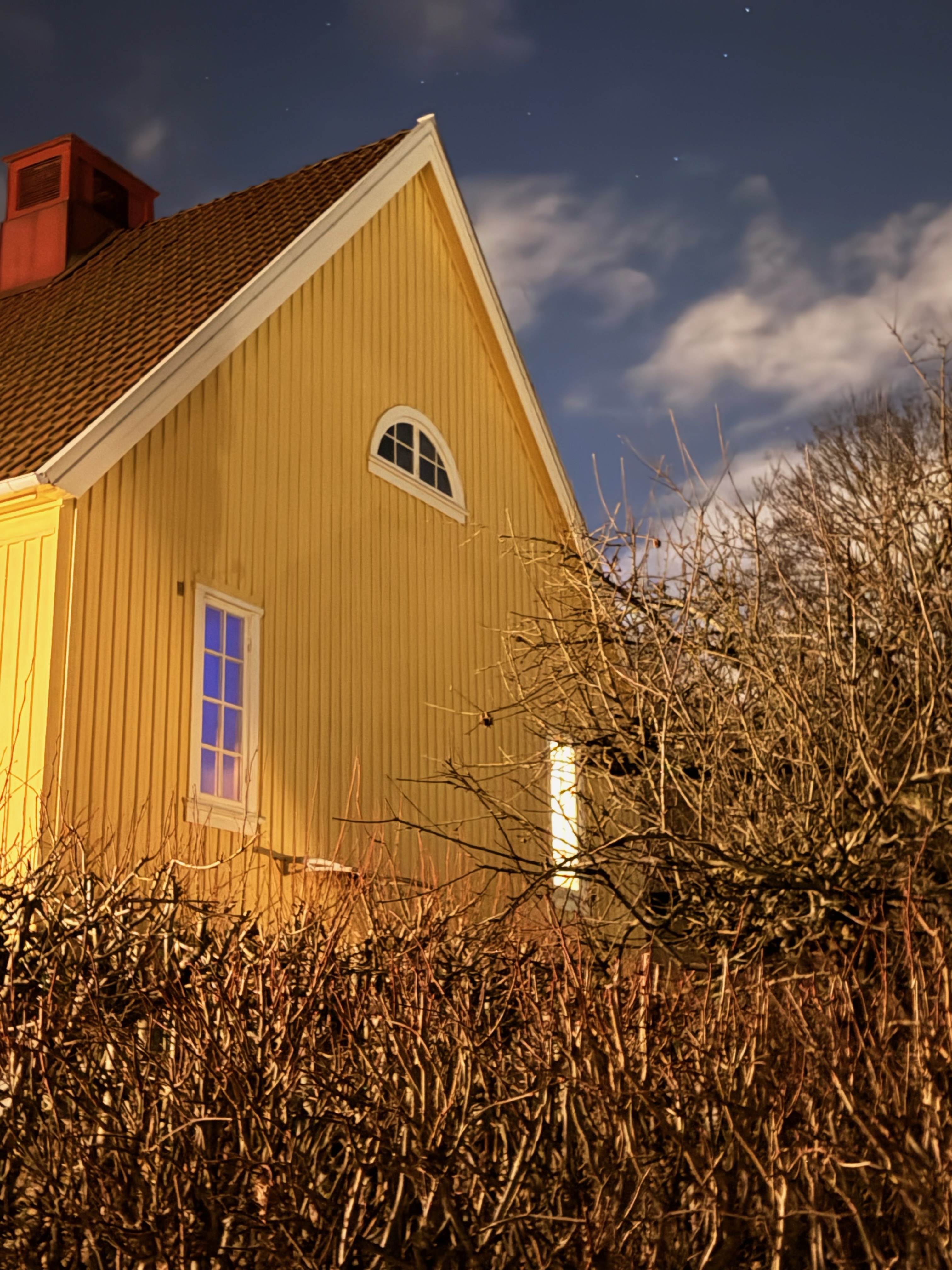 Gaveln med halvmånefönster i nattbelysning