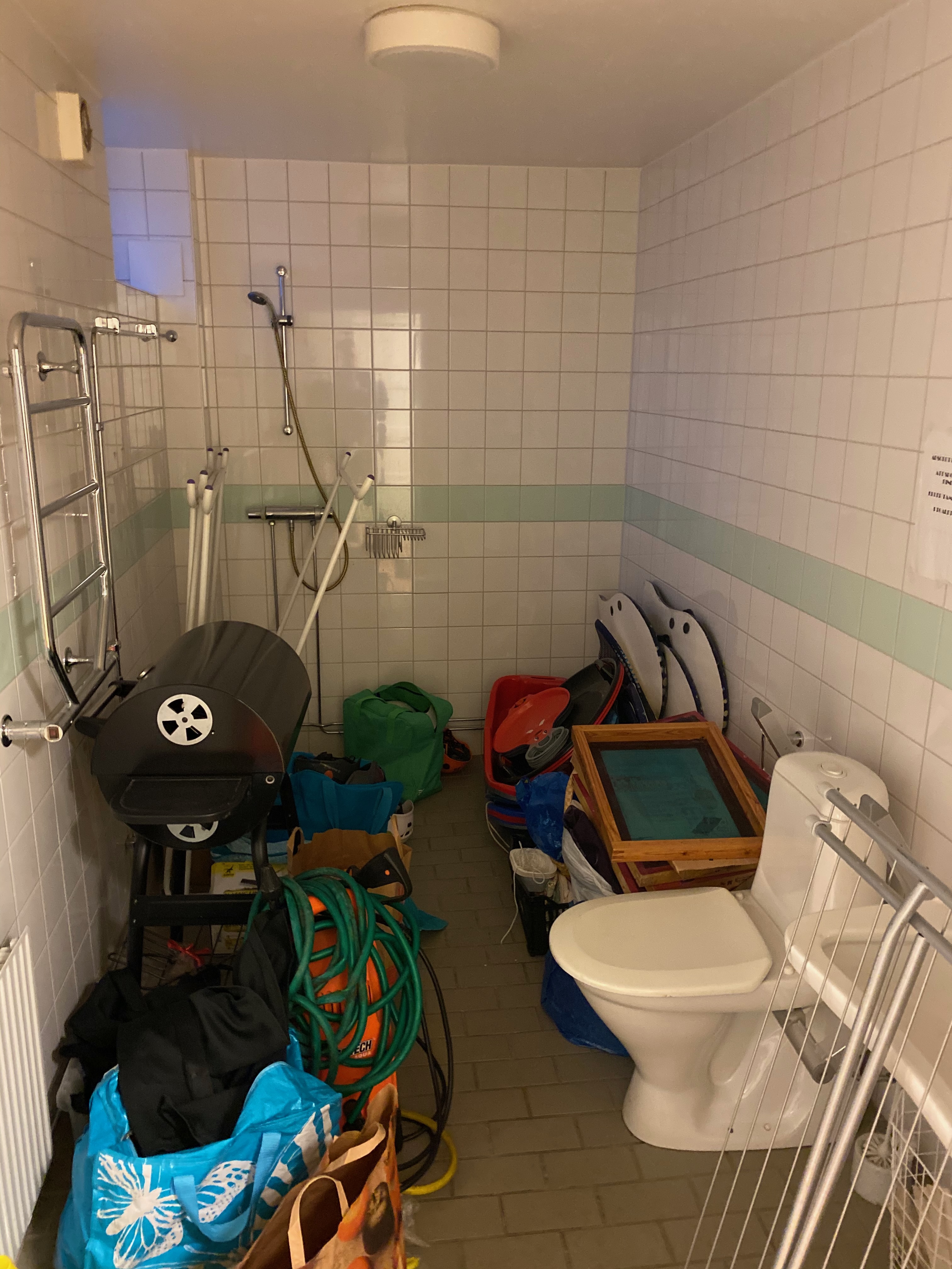 Duschrum använt som förråd med grill och trädgårdsslang