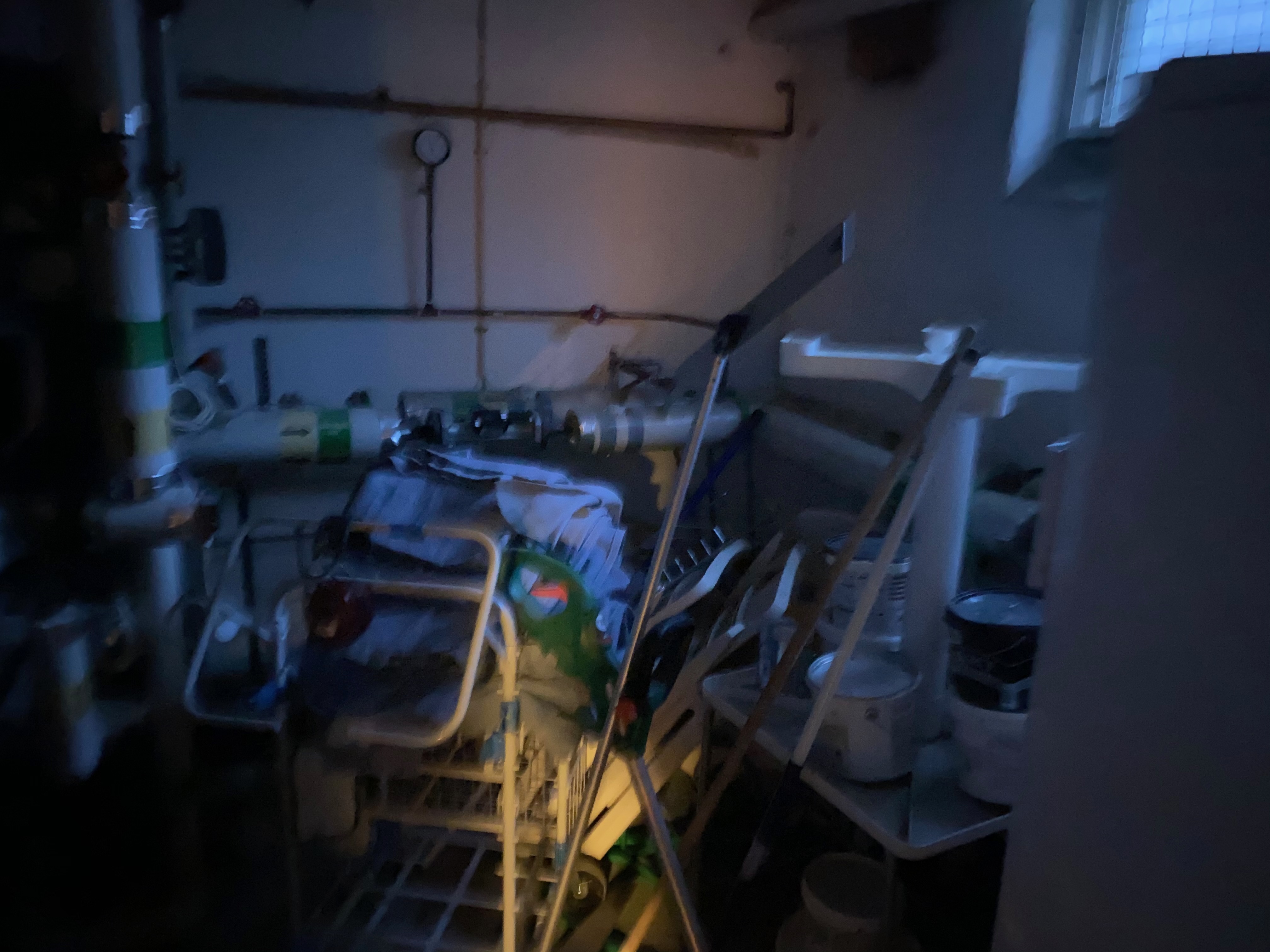 Mörkt teknikrum med rör och bråte