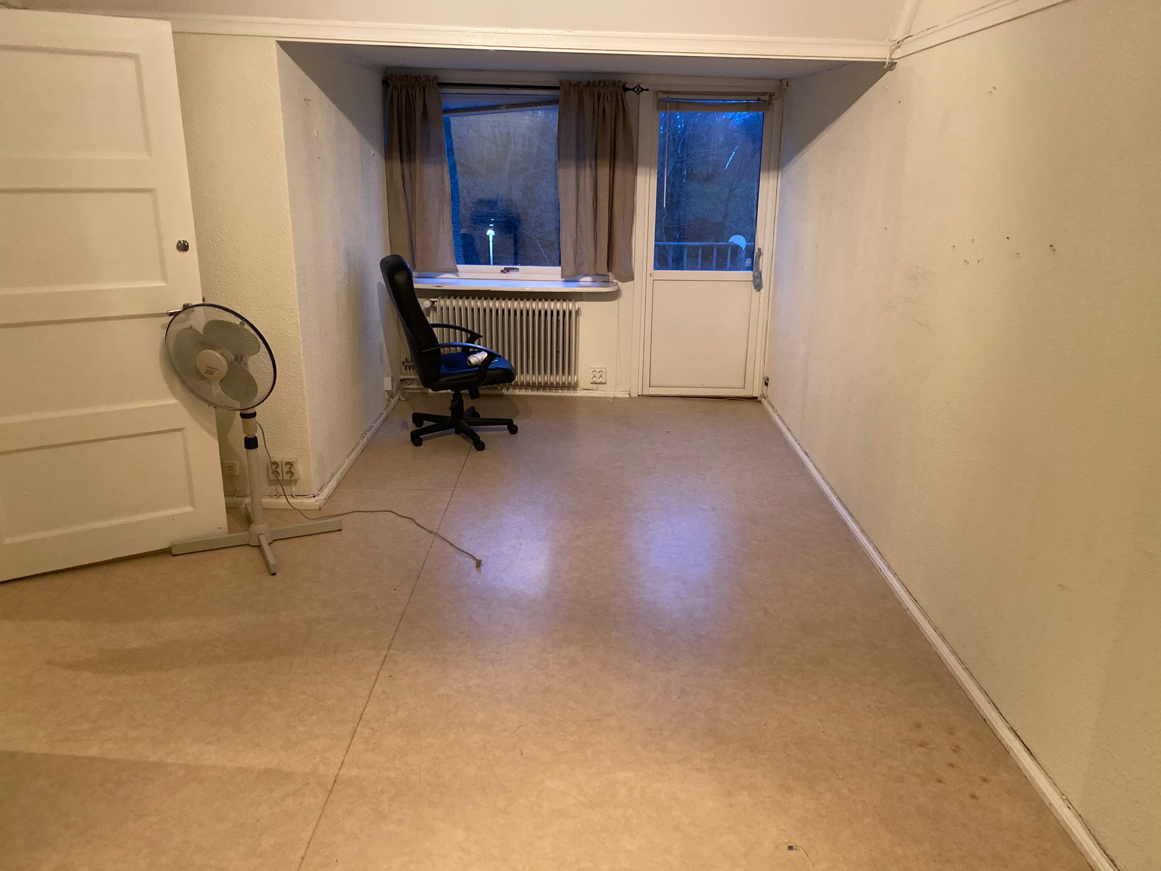 Tomt källarrum med kontorsstol och fläkt