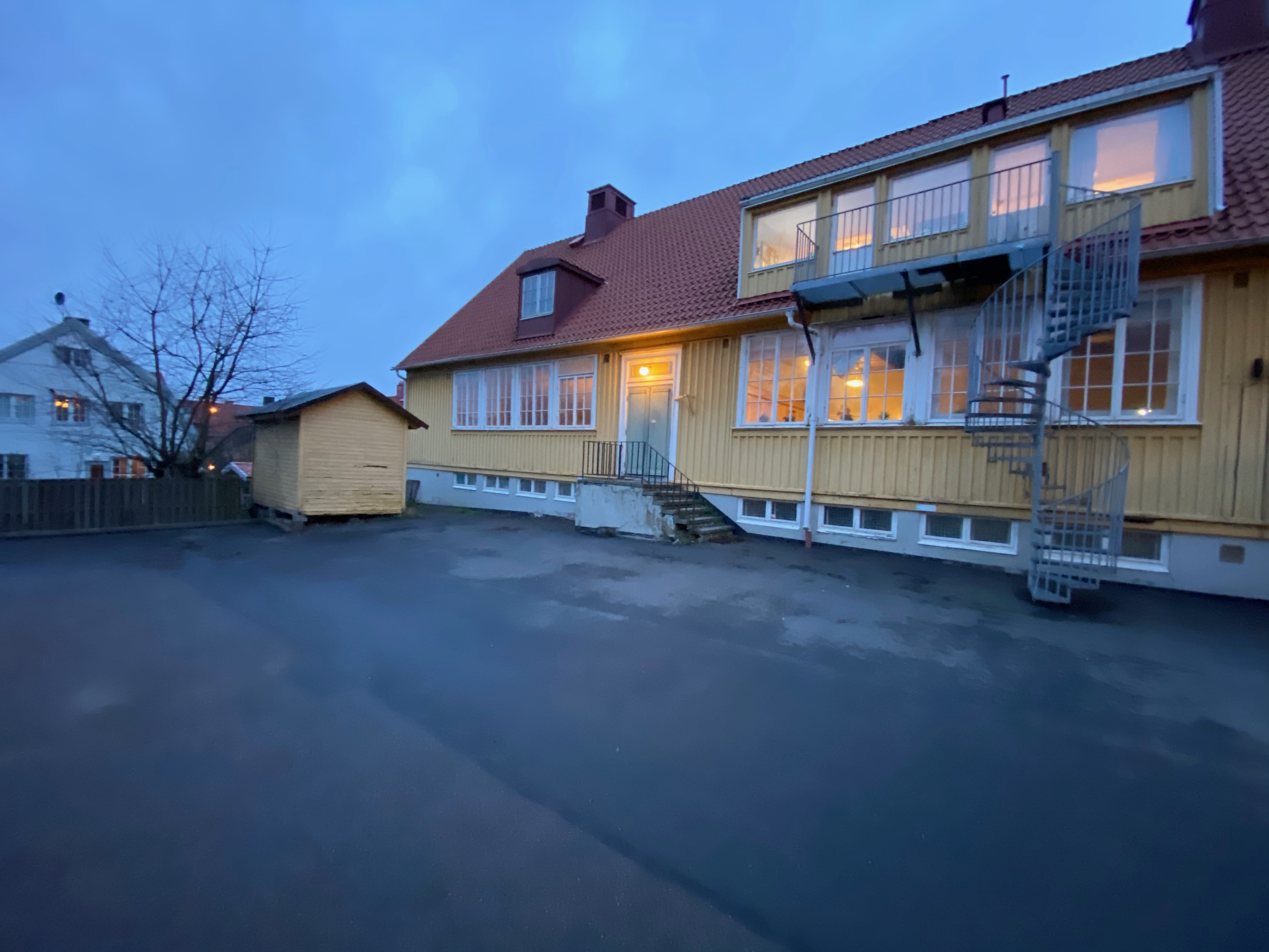 Baksidan med upplysta fönster och balkonger