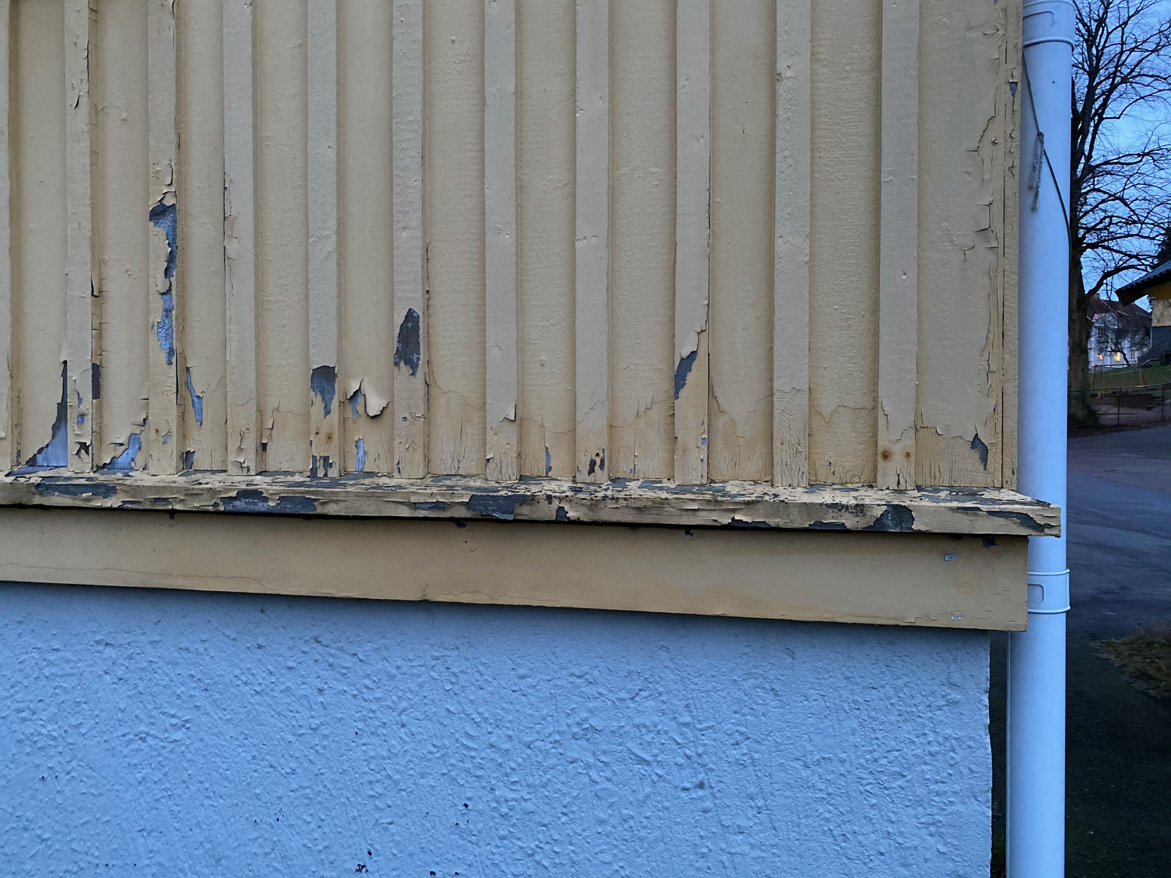 Flagnad gul färg avslöjar gammal blå färg under