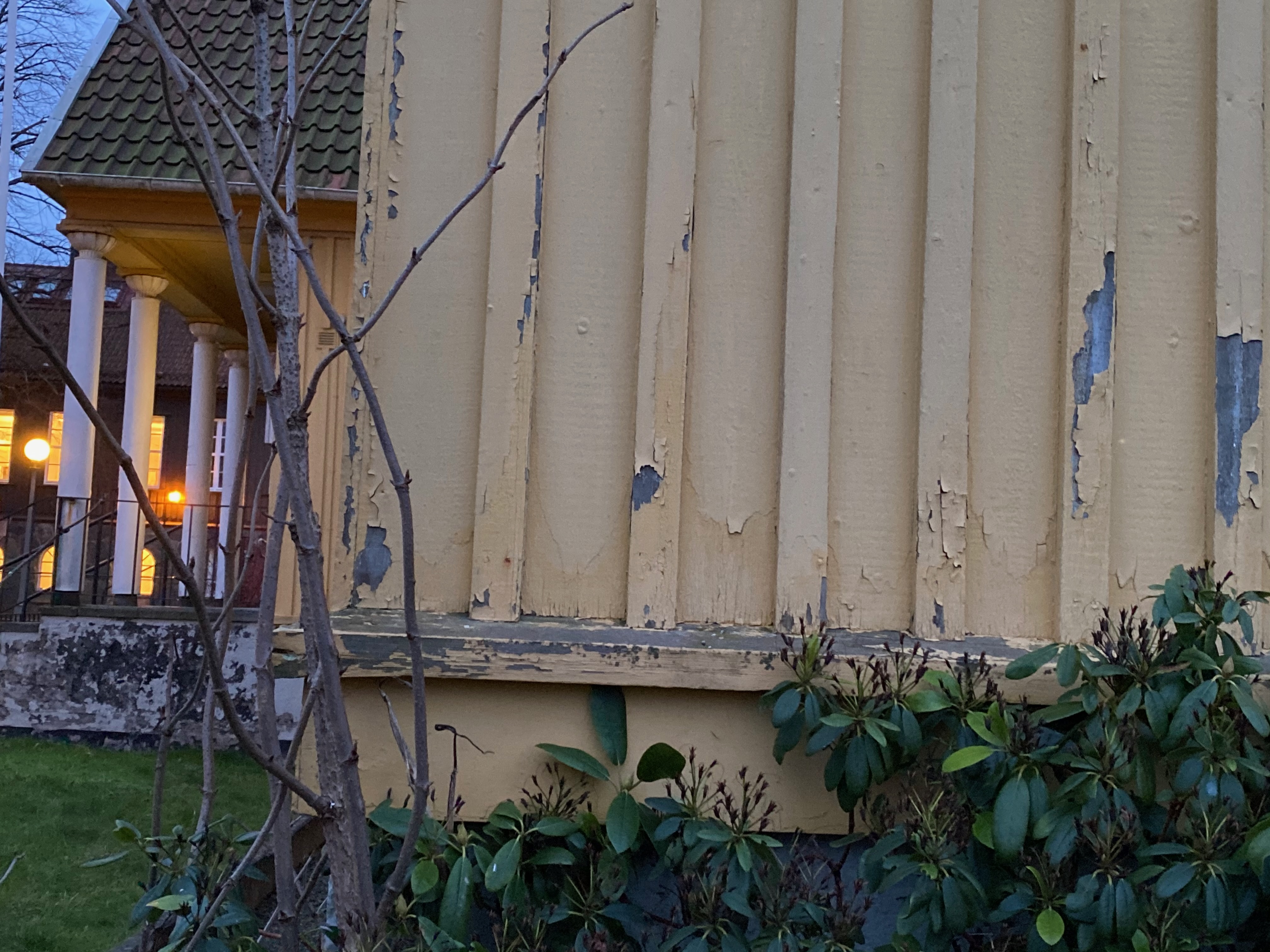 Flagnad färg på fasadhörn med verandapelare