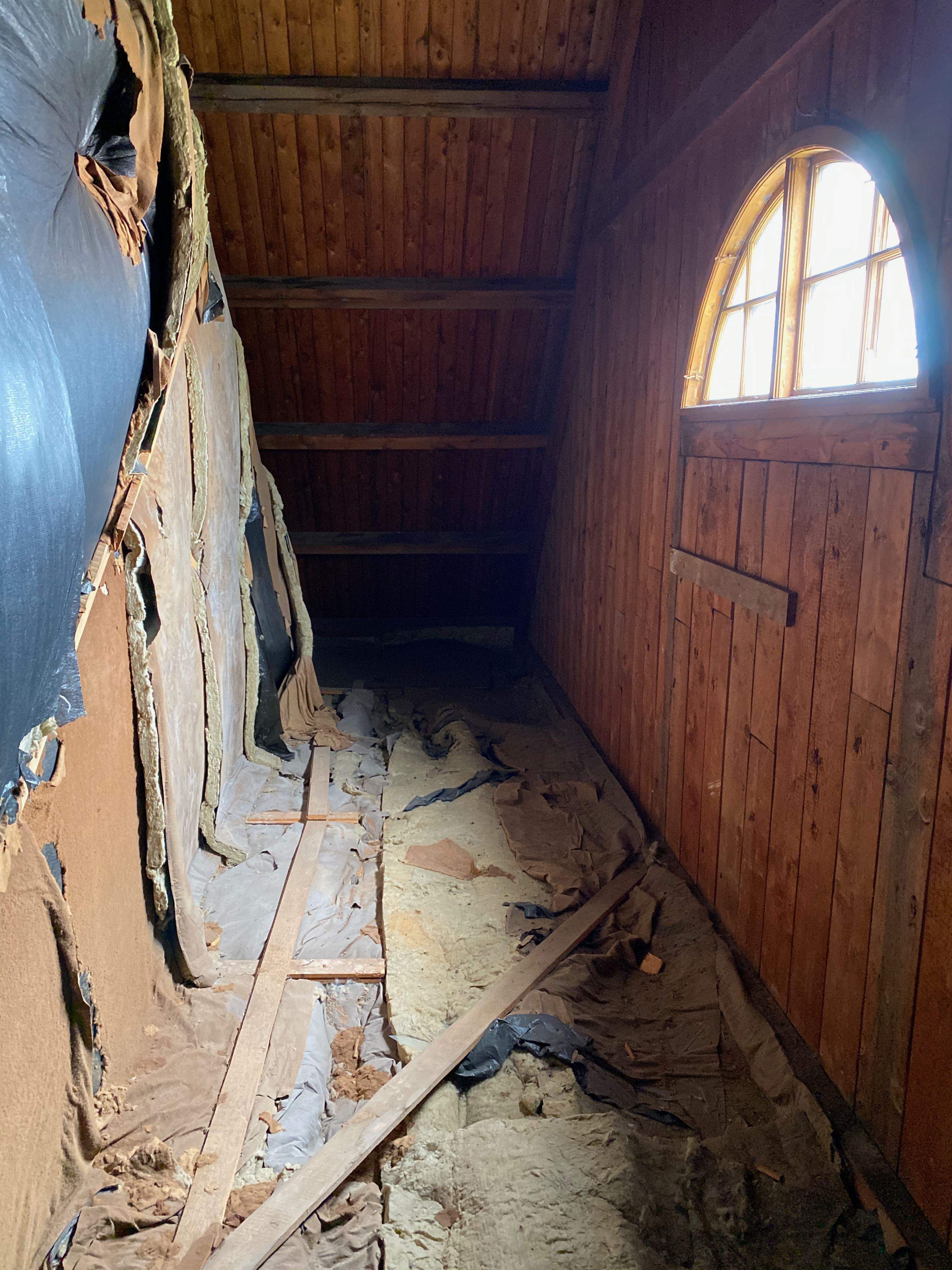 Vinden med riven isolering och blottlagt virke