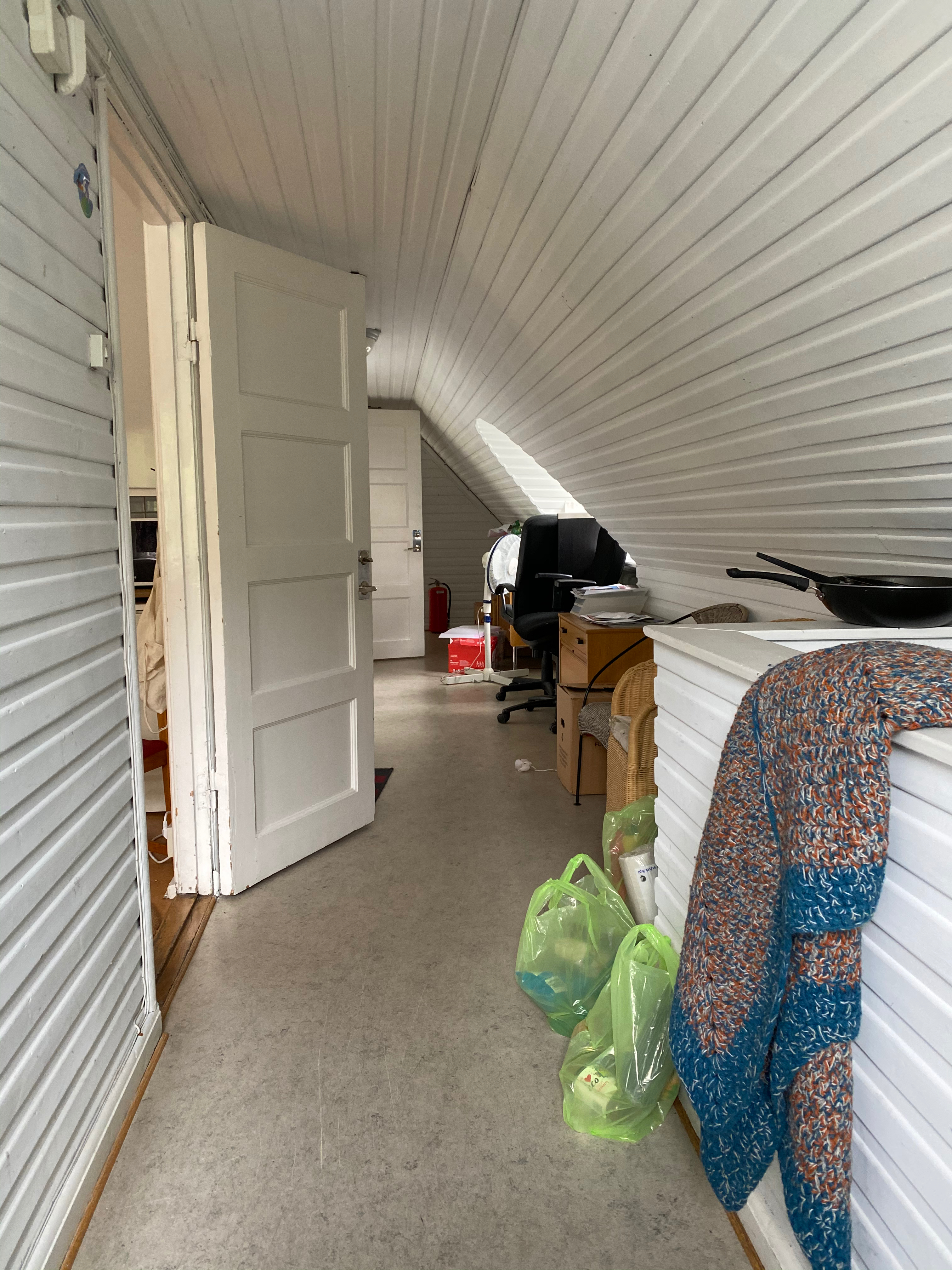 Smal vindskorridor med bagar och utrustning