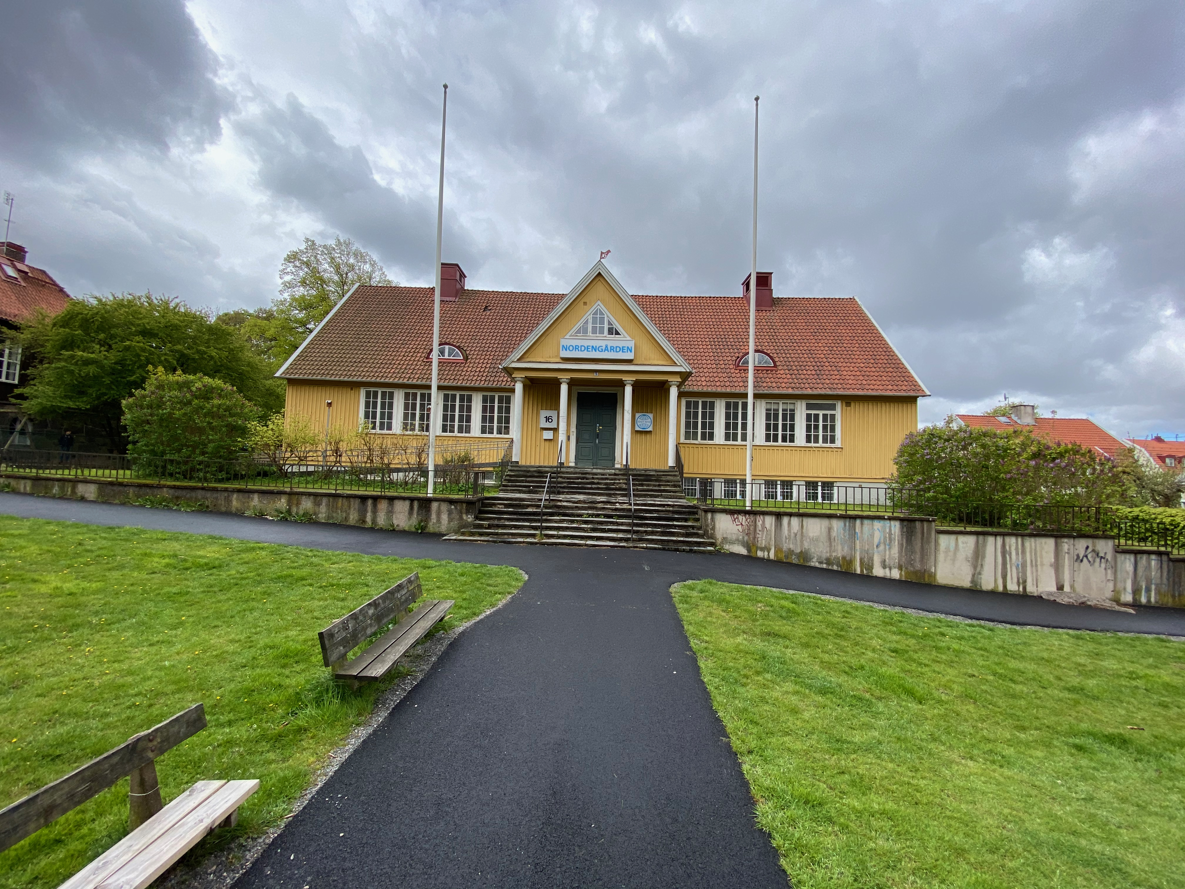 Framsidan med flaggstänger och skylt ovanför entrén