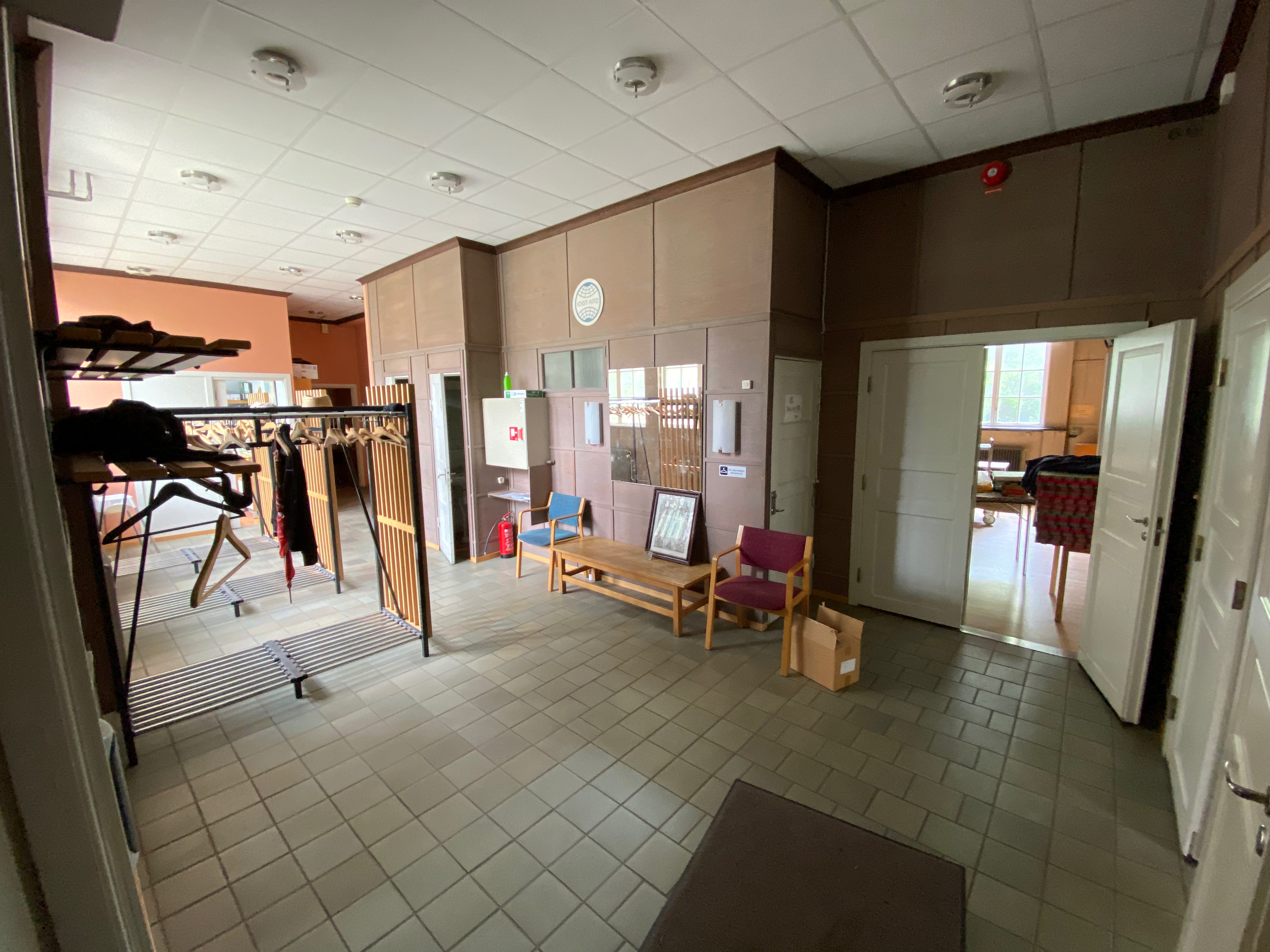 Entréhall med klocka, panelväggar och dörrar