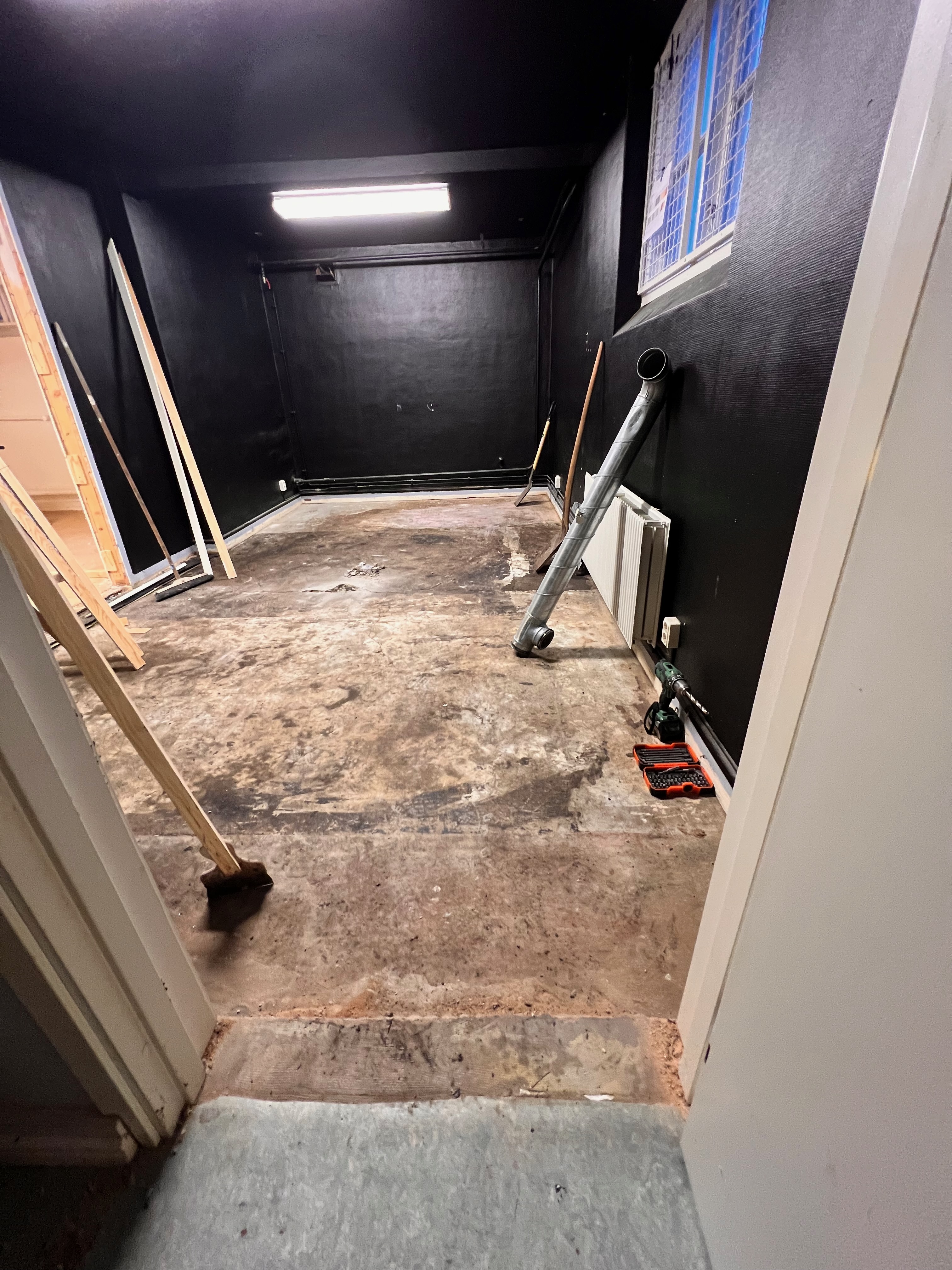 Källarrum målat svart med blottlagda rör