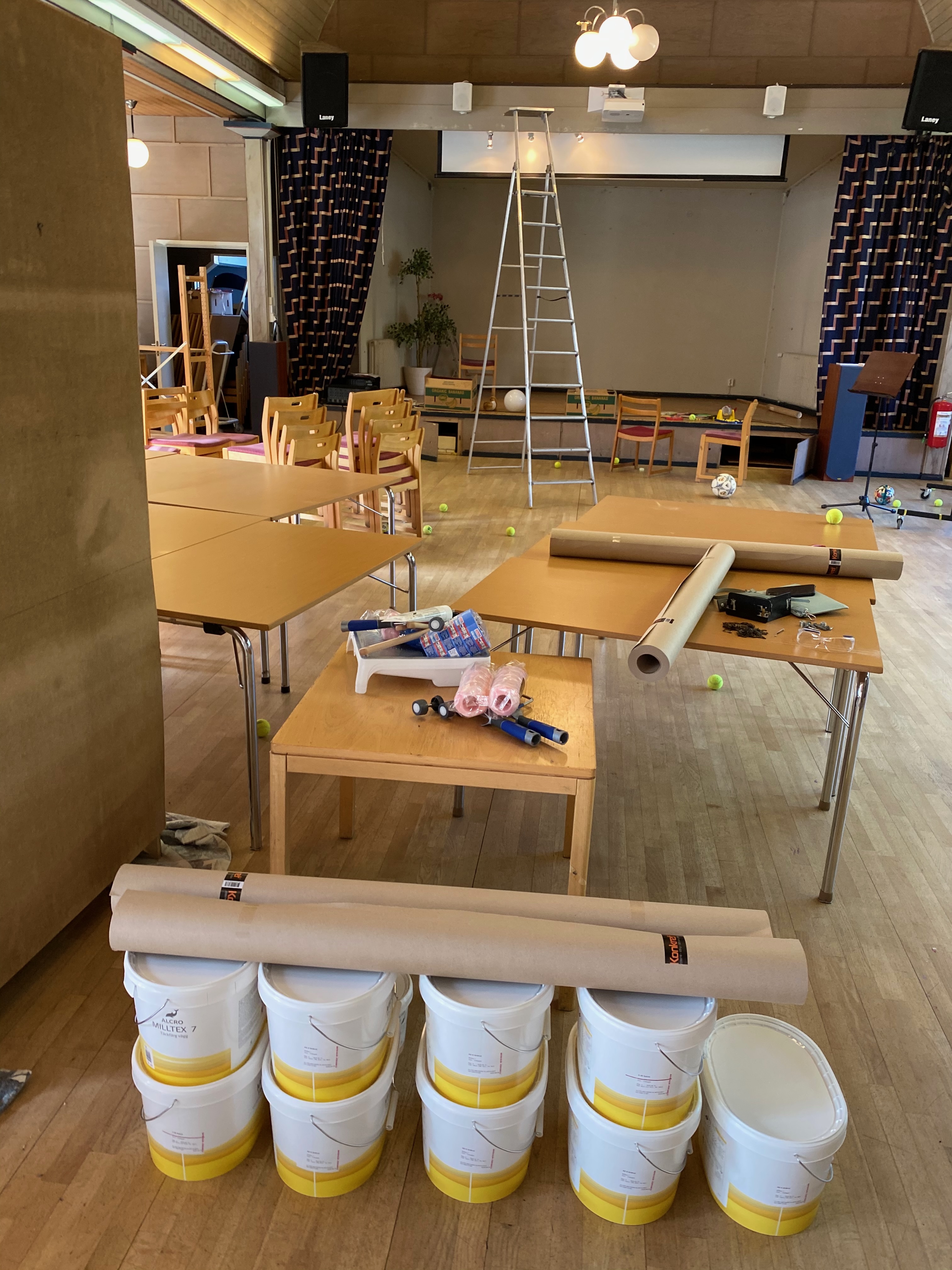 Salen som målaruppställning med hinkar, tapeter och stege