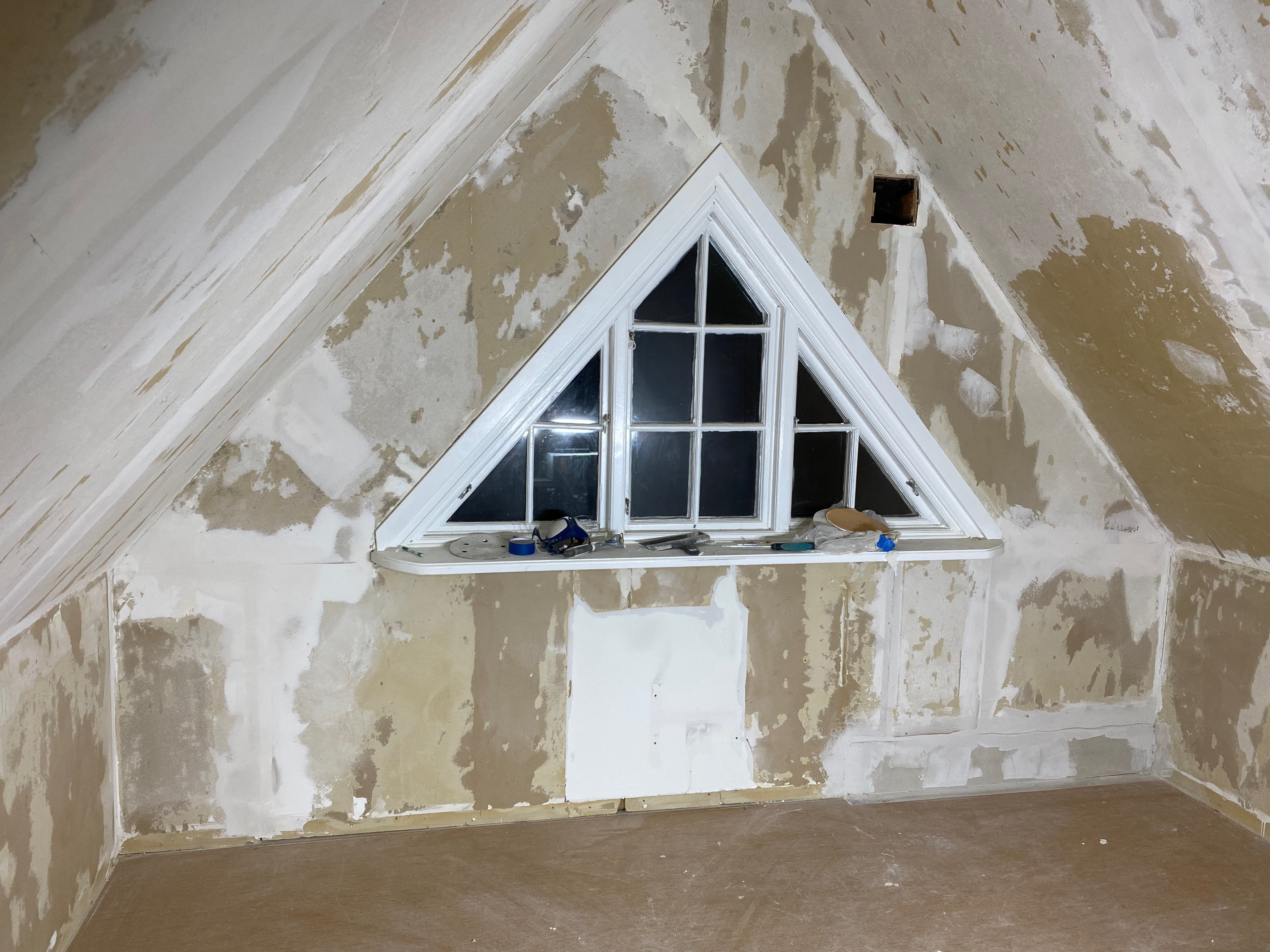 Vindsvåning under spackling med triangelfönster