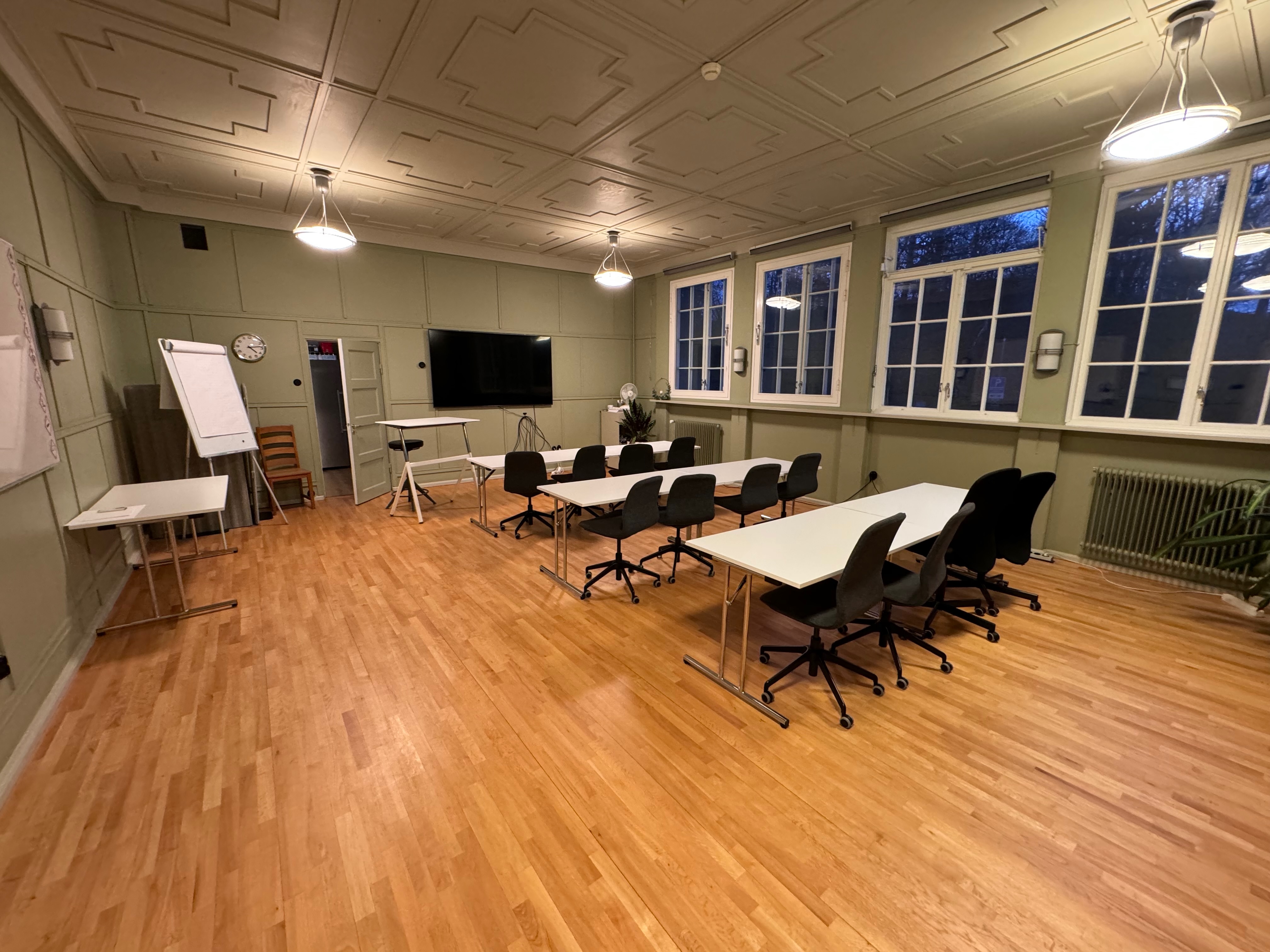 Konferensrum med långbord, TV och whiteboard