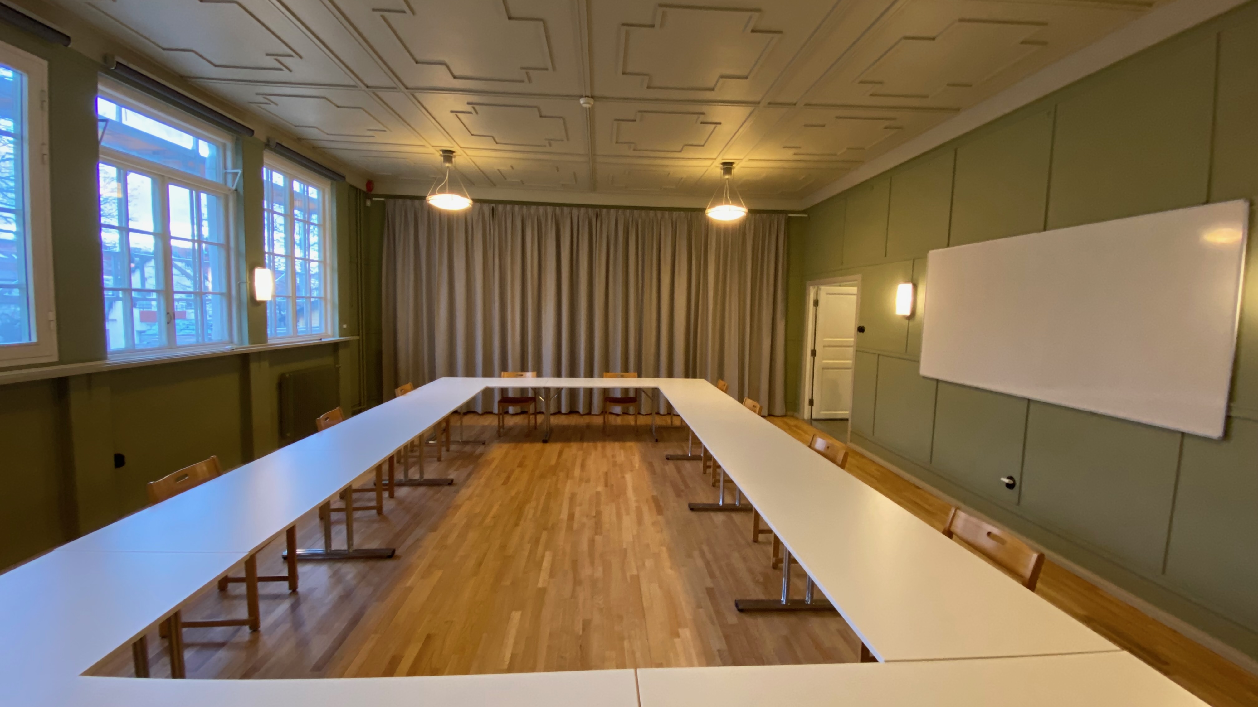 Konferensrummet med bordsuppställning och whiteboard